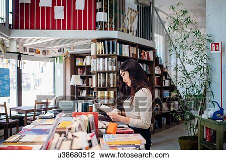 Young businesswoman browsing books in bookshop View Large Photo Image Stock Image - Young businesswoman browsing books in bookshop. Fotosearch