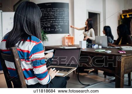 Young businesswoman doing presentation for female colleagues View Large Photo Image Picture - Young businesswoman doing presentation for female colleagues. Fotosearch