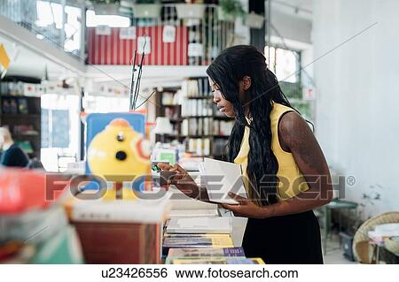 Young businesswoman looking at books in book shop View Large Photo Image Stock Photograph - Young businesswoman looking at books in book shop. Fotosearch
