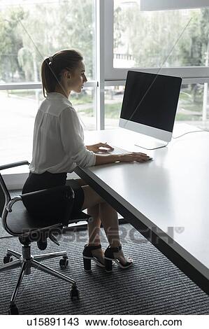 Young businesswoman working on desktop computer View Large Photo Image Stock Image - Young businesswoman working on desktop computer. Fotosearch