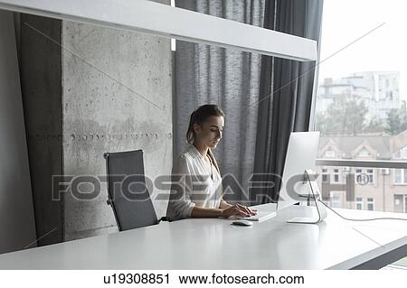 Young businesswoman working on desktop computer View Large Photo Image Stock Image - Young businesswoman working on desktop computer. Fotosearch