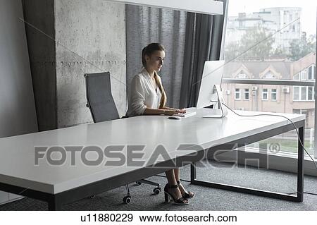 Young businesswoman working on desktop computer View Large Photo Image Stock Photo - Young businesswoman working on desktop computer. Fotosearch