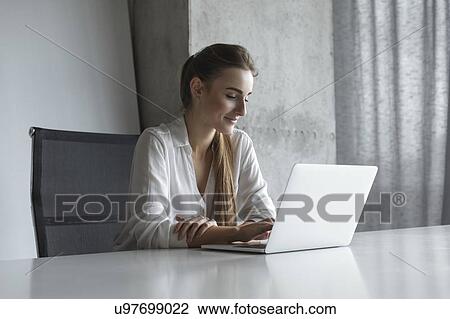 Young businesswoman working on laptop View Large Photo Image Stock Image - Young businesswoman working on laptop. Fotosearch