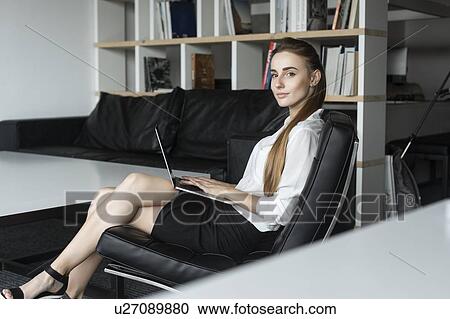 Young businesswoman working with laptop on sofa View Large Photo Image Stock Image - Young businesswoman working with laptop on sofa. Fotosearch