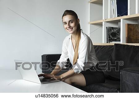 Young businesswoman working with laptop on sofa View Large Photo Image Stock Photograph - Young businesswoman working with laptop on sofa. Fotosearch