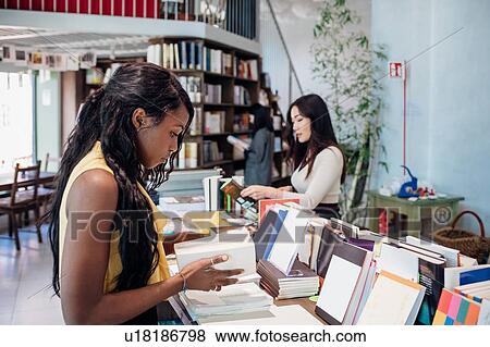 Young businesswomen browsing books in bookshop View Large Photo Image Stock Photo - Young businesswomen browsing books in bookshop. Fotosearch
