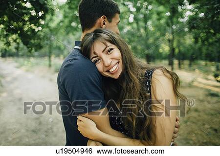 Young couple embracing in park View Large Photo Image Stock Photograph - Young couple embracing in park. Fotosearch