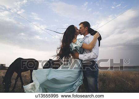 Young couple kissing in field by horses View Large Photo Image Stock Photography - Young couple kissing in field by horses. Fotosearch