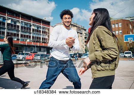 Young female and male adult friends having fun on city basketball court View Large Photo Image Picture - Young female and male adult friends having fun on city basketball court. Fotosearch