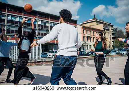 Young female and male adult friends playing basketball on city court View Large Photo Image Stock Image - Young female and male adult friends playing basketball on city court. Fotosearch