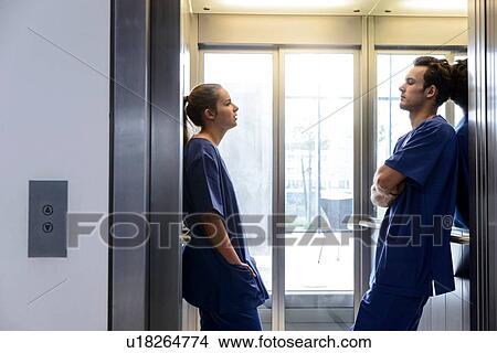 Young female and male junior doctors in hospital elevator View Large Photo Image Picture - Young female and male junior doctors in hospital elevator. Fotosearch