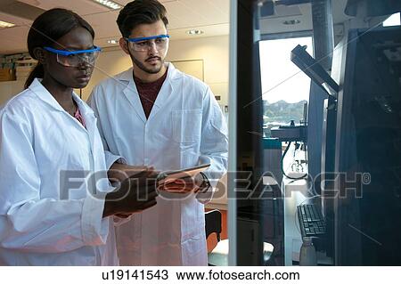 Young female and male scientists looking at scientific equipment in laboratory View Large Photo Image Stock Image - Young female and male scientists looking at scientific equipment in laboratory. Fotosearch