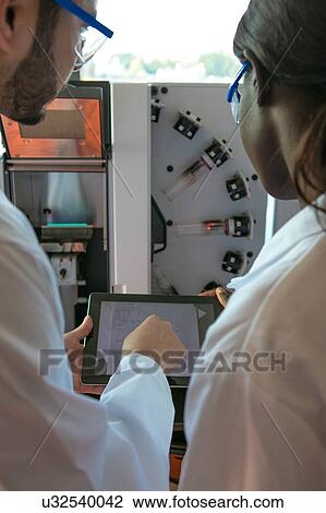 Young female and male scientists looking at digital tablet in laboratory, over shoulder view View Large Photo Image Stock Image - Young female and male scientists looking at digital tablet in laboratory, over shoulder view. Fotosearch