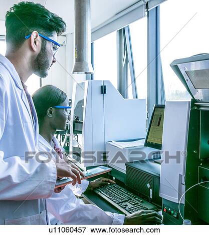 Young female and male scientists looking at computer in laboratory View Large Photo Image Stock Photo - Young female and male scientists looking at computer in laboratory. Fotosearch