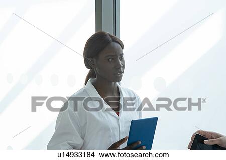 Young female and male scientists with digital tablet and smartphone having discussion in laboratory, cropped View Large Photo Image Picture - Young female and male scientists with digital tablet and smartphone having discussion in laboratory, cropped. Fotosearch
