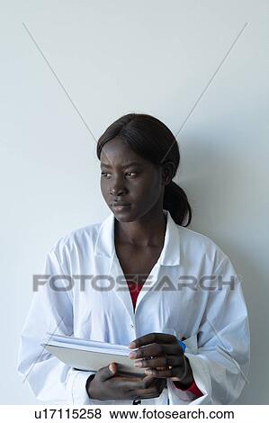 Young female scientist leaning against laboratory wall holding notebook, portrait View Large Photo Image Stock Photo - Young female scientist leaning against laboratory wall holding notebook, portrait. Fotosearch