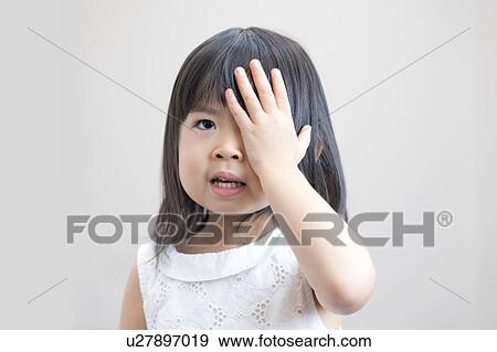 Young girl covering eye with hand, studio shot. View Large Photo Image Stock Photo - Young girl covering eye with hand, studio shot.. Fotosearch