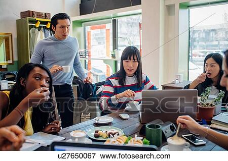 Young male and female business team sharing working lunch at cafe table View Large Photo Image Stock Photo - Young male and female business team sharing working lunch at cafe table. Fotosearch