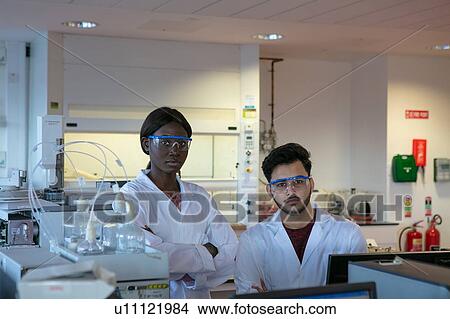 Picture - Young male and female scientists in laboratory, portrait. Fotosearch