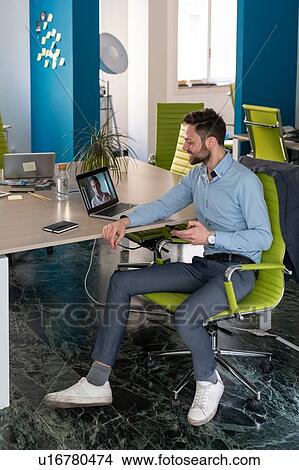 Young male business creative having video call meeting with client on office laptop View Large Photo Image Picture - Young male business creative having video call meeting with client on office laptop. Fotosearch