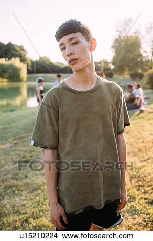 Picture - Young man and friends by lake. Fotosearch