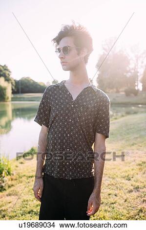 Picture - Young man by lake. Fotosearch