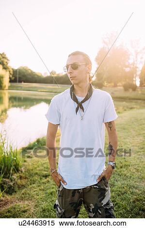 Stock Photography - Young man by lake. Fotosearch