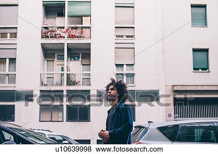 Stock Photo - Young man exploring city, Milano, Lombardia, Italy. Fotosearch