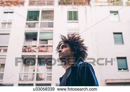 Stock Photo - Young man exploring city, Milano, Lombardia, Italy. Fotosearch