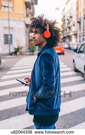 Stock Photo - Young man exploring city, Milano, Lombardia, Italy. Fotosearch