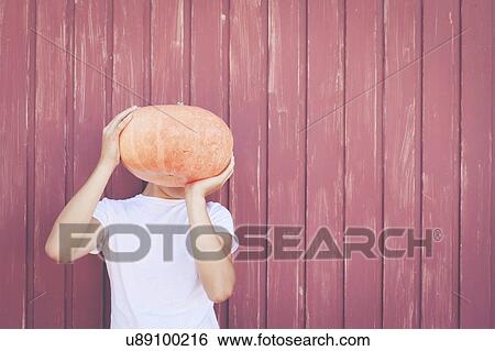 Young man holding pumpkin over his face View Large Photo Image Stock Photograph - Young man holding pumpkin over his face. Fotosearch