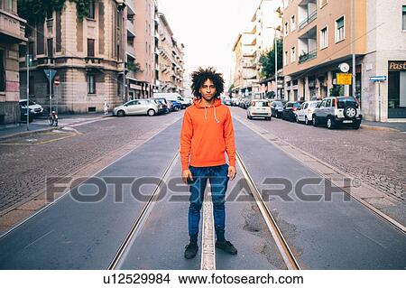 Picture - Young man in middle of city street, Milano, Lombardia, Italy. Fotosearch