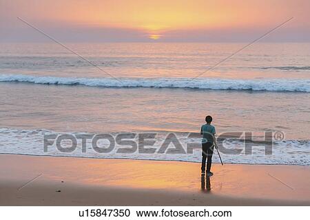 Young man on beach at sunset in Lisbon, Portugal View Large Photo Image Stock Image - Young man on beach at sunset in Lisbon, Portugal. Fotosearch