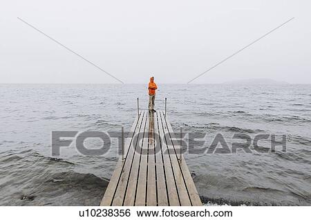 Young man on pier on Iceland View Large Photo Image Stock Photograph - Young man on pier on Iceland. Fotosearch
