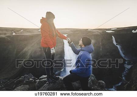 Young man proposing to his girlfriend while hiking by Haifoss waterfall in Iceland View Large Photo Image Stock Image - Young man proposing to his girlfriend while hiking by Haifoss waterfall in Iceland. Fotosearch
