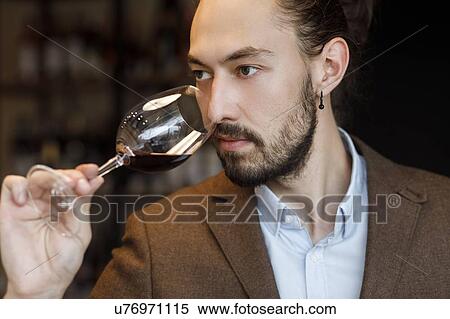 Young man smelling wine in glass at tasting View Large Photo Image Stock Photography - Young man smelling wine in glass at tasting. Fotosearch