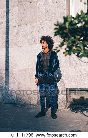 Young man waiting in front of concrete wall View Large Photo Image Stock Photograph - Young man waiting in front of concrete wall. Fotosearch