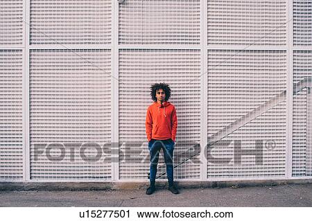 Young man waiting in front of wall with steel frames View Large Photo Image Stock Image - Young man waiting in front of wall with steel frames. Fotosearch
