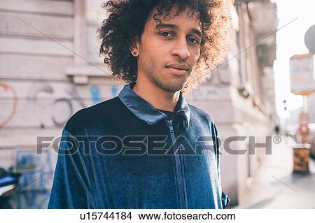 Picture - Young man waiting on pavement. Fotosearch