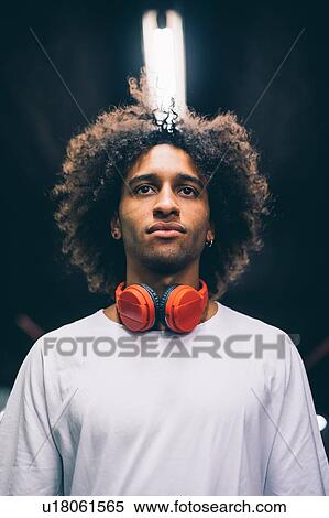 Young man with headphones around neck View Large Photo Image Stock Photography - Young man with headphones around neck. Fotosearch