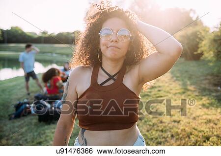 Stock Photograph - Young woman and friends by lake. Fotosearch
