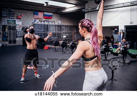 Young woman and man training, lifting dumbbells in gym View Large Photo Image Stock Photography - Young woman and man training, lifting dumbbells in gym. Fotosearch
