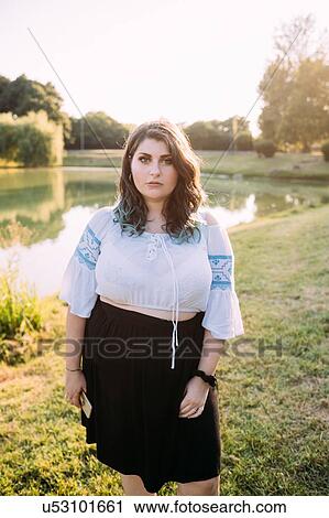 Stock Image - Young woman by lake. Fotosearch