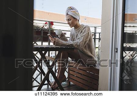 Young woman drinking coffee on apartment balcony View Large Photo Image Stock Photography - Young woman drinking coffee on apartment balcony. Fotosearch