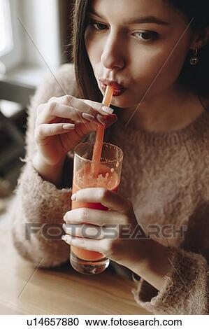 Stock Image - Young woman drinking juice. Fotosearch