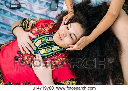 Young woman enjoying face massage by friend View Large Photo Image Stock Image - Young woman enjoying face massage by friend. Fotosearch