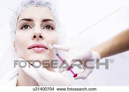 Picture - Young woman having a plasma and hyaluronic acid injection in her face to rejuvenate and smooth skin, close-up.. Fotosearch