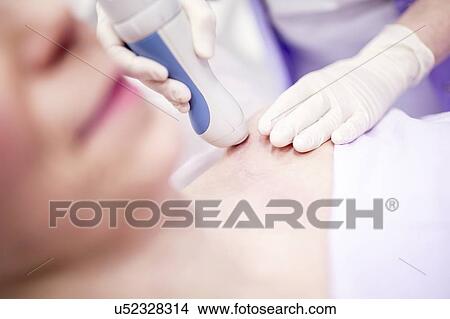 Picture - Young woman having laser peeling treatment, close-up. This treatment smooths and rejuvenates the skin.. Fotosearch