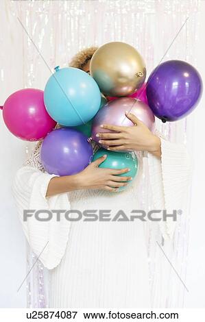 Stock Photo - Young woman holding balloons. Fotosearch
