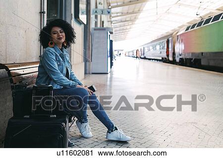 Young woman holding smart phone on railway platform View Large Photo Image Stock Image - Young woman holding smart phone on railway platform. Fotosearch
